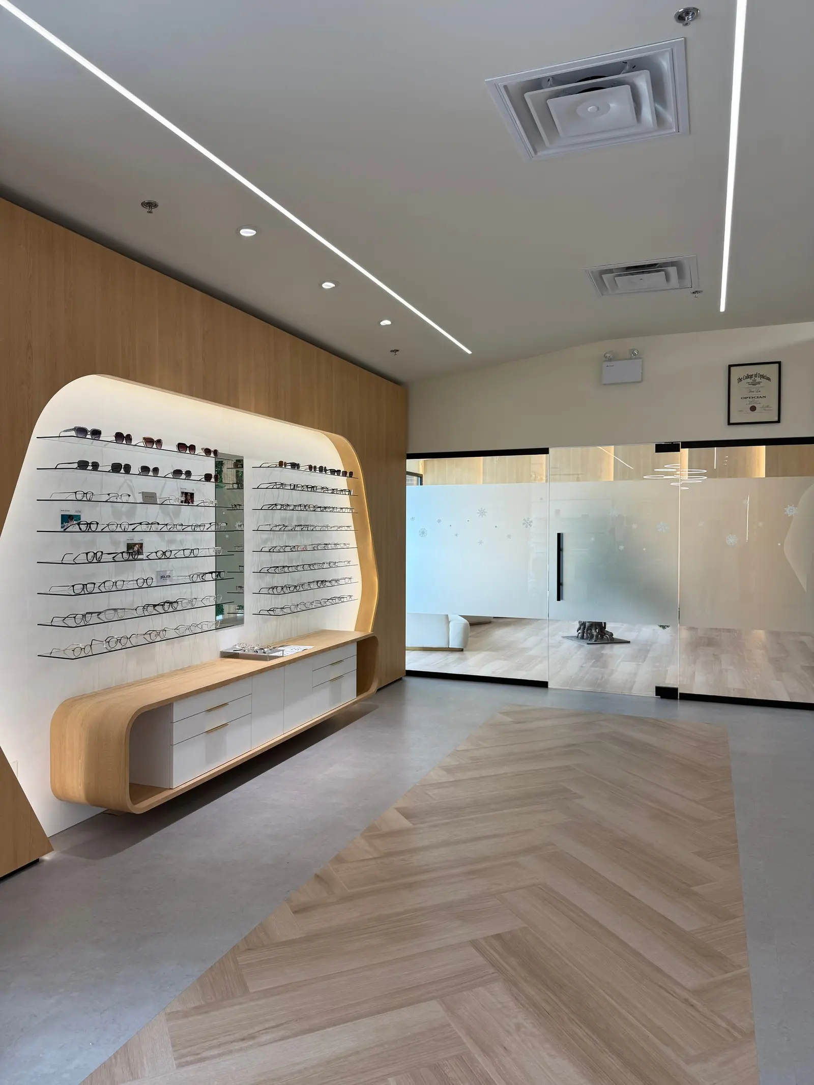 Herringbone floor leading past the eyewear wall to the clinic
